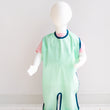 Load image into Gallery viewer, Single Layer Grass (green) full length bib. This single-layer bib gives you the perfect combination of coziness and protection; its lightweight, soft fabric prevents messes from staining your home, and the waterproof polyurethane laminate (PUL) won't shrink or fade even with heavy use.