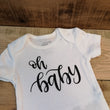 Load image into Gallery viewer, white newborn diaper shirt that says "oh baby" in black script made by All Decked Out Events in Sherwood Park Alberta