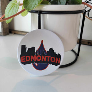 Smooth matte finish ceramic coaster with the word "Edmonton" in orange lettering outlined in the Edmonton cityline over an Oilers oil drop. Bumper dots on the bottom