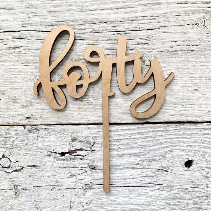 Laser engraved wooded cake topper of the word "forty".