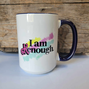 15oz ceramic mug that says "I am Kenough" in black lettering with a barbie fond pink 'K' and a yellow, pink, and blue splash background. The mug is dishwasher safe but handwash is recommended