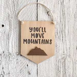 Laser engraved 3D wall flag that says "You'll move mountains" with a mountain range