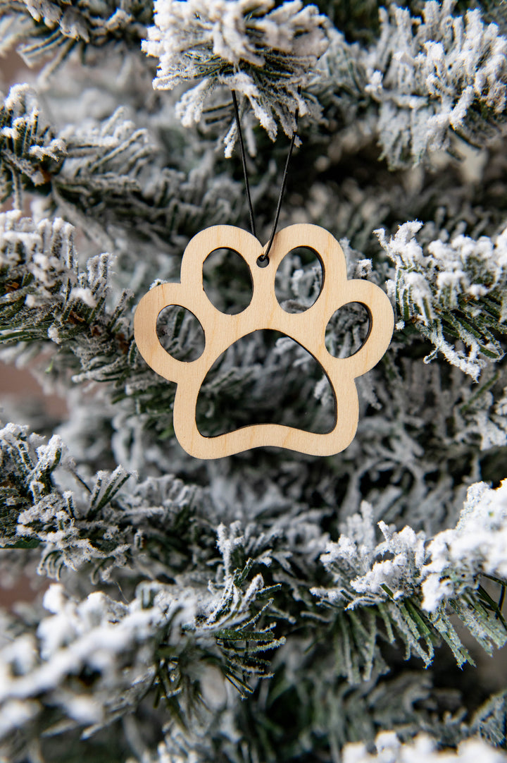 Approx. 3" Christmas ornament laser cut from Baltic Birch in the outline of a paw print. The ornament is pre-strung and ready for hanging