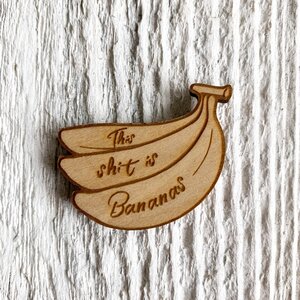 2 inch birch plywood magnet in the shape of a bunch of bananas that says "this shit is bananas".