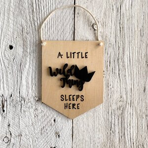 Laser engraved 3D wall flag that says "A little wile thing sleeps here"