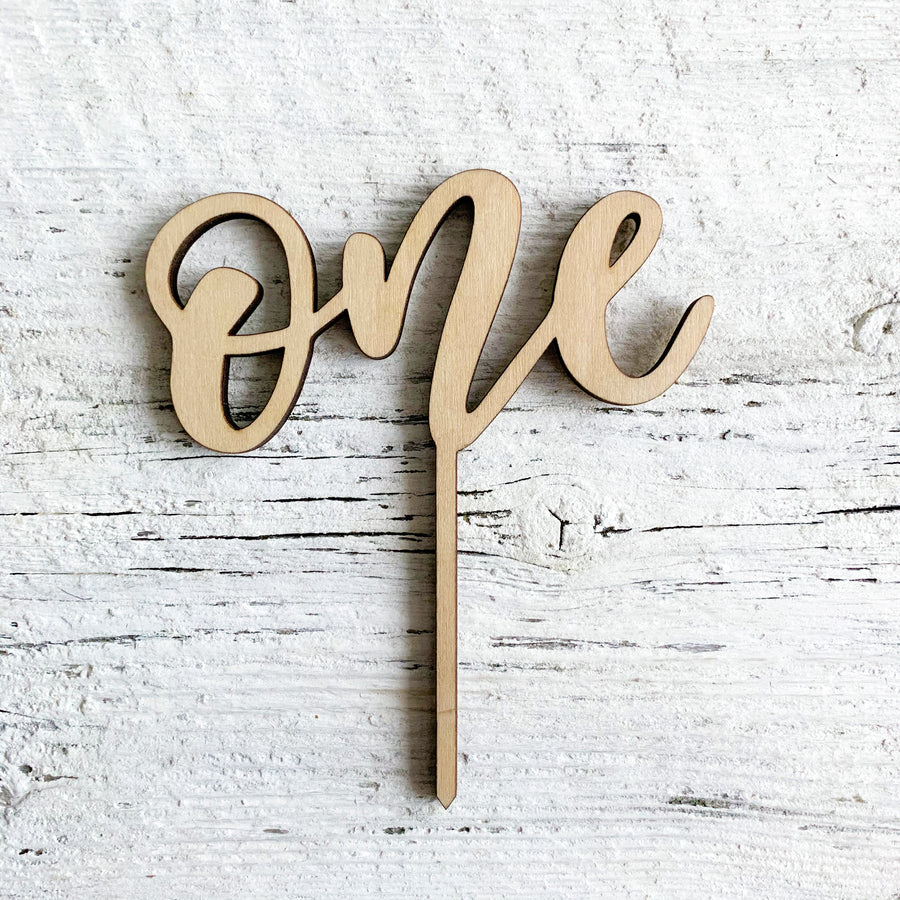 Wooden laser engraved cake topper of the word "One".