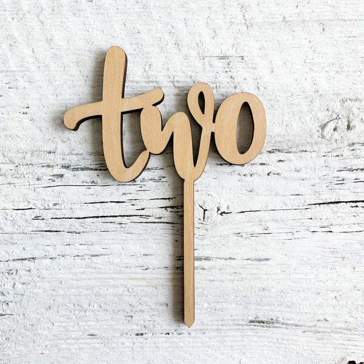 Laser engraved wooden cake topper with the word "two".