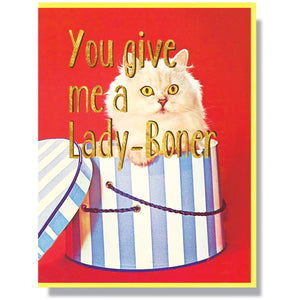 This A2 (4.25” x 5.5”) card is digitally printed with gold foil is blank inside and comes with a yellow envelope. The front of the card has a cat coming out of a present and says "You give me a lady-boner" in gold lettering.