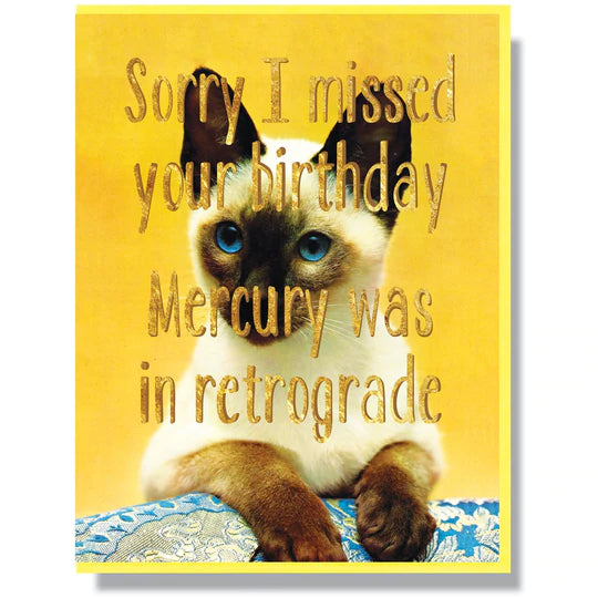 This A2 (4.25” x 5.5”) belated-birthday card is digitally printed with gold foil, is blank inside, and comes with a yellow envelope. The front of the card has a cat and says "Sorry I missed your birthday Mercury was in retrograde" in gold lettering.