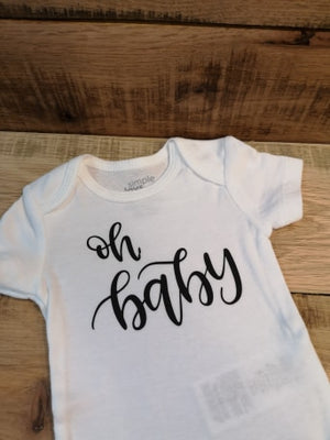 white newborn diaper shirt that says "oh baby" in black script made by All Decked Out Events in Sherwood Park Alberta