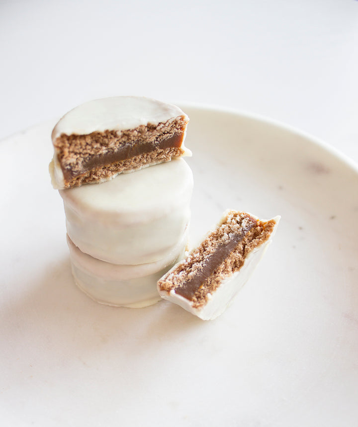 Argentine classic - two honey-shortbread cookies, with a rich Dulce de Leche filling, and coated in delicious sweet white chocolate.